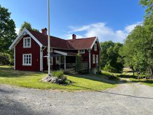 a red house with a pole in front of it at Kyrkliden in Torestorp