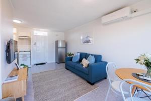 a living room with a blue couch and a table at Stunning Apartment In South Perth in Perth