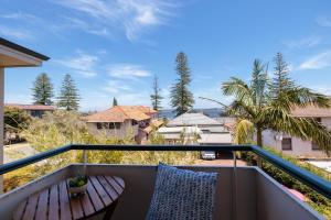 a balcony with a wooden bench and palm trees at Stunning Apartment In South Perth in Perth