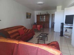 a living room with a couch and a table at Appartement spacieux in Sainte-Clotilde