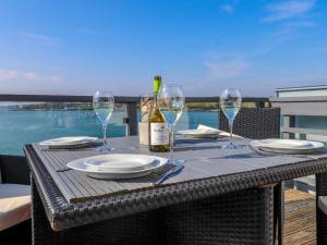 una mesa con una botella de vino y copas en White Sails en Y Felinheli
