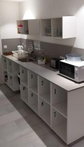 a kitchen with white cabinets and a counter with a microwave at Hostel Central Sevilla in Seville