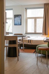 a room with a bed and a table and chairs at Smartflats - L'Orangerie I Maastricht in Maastricht