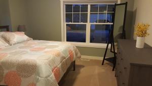 a bedroom with a bed and a window and a dresser at Modern and Pristine Condo -By the GT Commons in Traverse City
