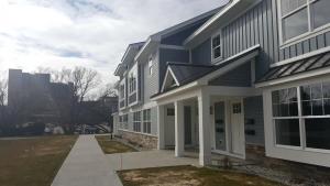 a blue house with a sidewalk in front of it at Modern and Pristine Condo -By the GT Commons in Traverse City