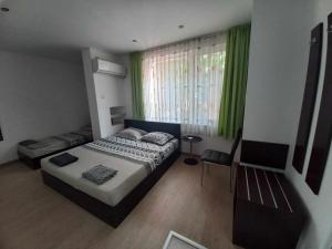 um quarto com uma cama e uma janela com cortinas verdes em Стаи за гости Калина em Yambol