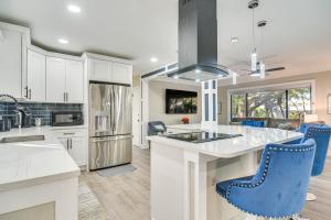 a kitchen with white cabinets and blue chairs at Serene St Petersburg Home with Private Hot Tub in St Petersburg