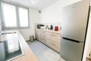 uma cozinha com um frigorífico de aço inoxidável e armários de madeira em The pretty urban harmony - 2 rooms #GM em Grenoble