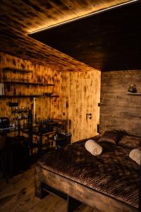 ein Schlafzimmer mit einem Bett in einem Zimmer mit Holzwänden in der Unterkunft Treedom in Prievidza