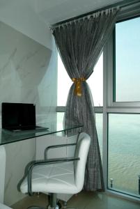 een glazen bureau met een stoel voor een raam bij Ecusuites Studio Two Riverfront con Jacuzzi Hidro Privado in Guayaquil