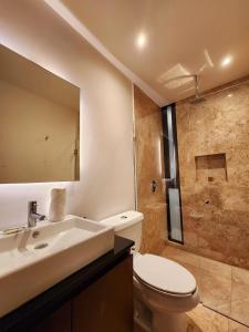 een badkamer met een toilet, een wastafel en een douche bij Meliora by Bunik in Playa del Carmen