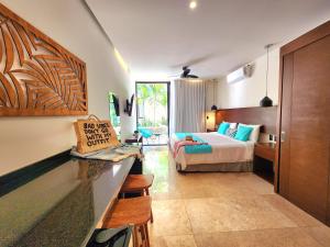 una camera d'albergo con letto e cucina con bancone di Meliora by Bunik a Playa del Carmen