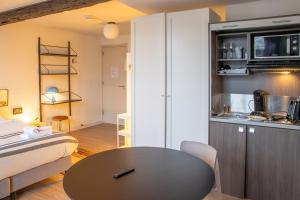 une petite chambre avec une table et une cuisine dans l'établissement Smartflats - L'Orangerie I Maastricht, à Maastricht