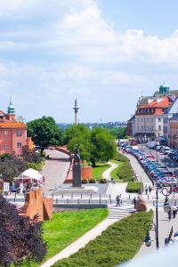 a city with a statue in the middle of a street at Podwale str Large flat in the heart of Old Town in Warsaw