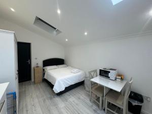 - une chambre avec un lit et une table avec un four micro-ondes dans l'établissement Studio room next to Gatwick, à Crawley