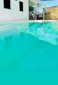 a swimming pool with blue water in a house at Ola Azul Monterrico, apartamento de playa completamente equipado y con piscina privada. in Monterrico