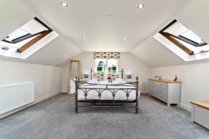 a bedroom with skylights and a bed in a attic at Piggery Cottage in Llanasa