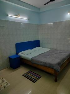 a bed with a blue headboard in a room at Hotel basanti in Puri