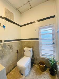 baño con aseo blanco y ventana en Madiha Lodge by Land of Rizka, en Matara