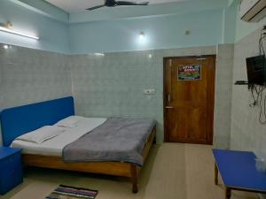 a bedroom with a bed and a wooden door at Hotel basanti in Puri