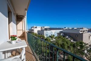 een balkon met een tafel en uitzicht op de stad bij Elide Apartments - Comfort in Polignano a Mare