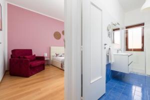 uma casa de banho com uma cadeira vermelha e um quarto em Smart Home Sorrento - City center em Sorrento