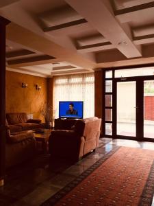 a living room with two couches and a flat screen tv at HOTEL ORA in Pristina