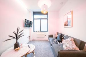 a living room with a couch and a table at Hayy ApartHotels Stanley Mills in Huddersfield