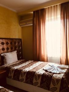 um quarto com uma cama grande e uma janela em HOTEL ORA em Pristina