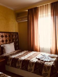 a bedroom with a large bed with a window at HOTEL ORA in Prishtinë