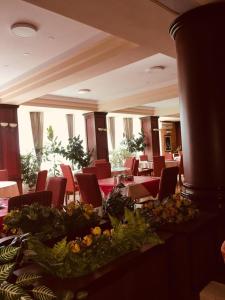 ein Esszimmer mit roten Stühlen und einem Tisch mit Blumen in der Unterkunft HOTEL ORA in Pristina