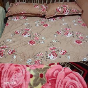 łóżko z różowymi i białymi kwiatami w obiekcie S H coorg homestay w mieście Madikeri