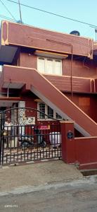 czerwony dom z bramą i budynkiem w obiekcie S H coorg homestay w mieście Madikeri