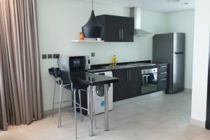 uma cozinha com armários pretos e um balcão preto em New Cozy Sea View Apartment em Manama