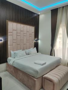 sypialnia z dużym łóżkiem z dużym zagłówkiem w obiekcie Passready Hotel and Suites Nnewi w mieście Nnewi