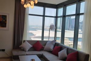 a living room with a couch and a large window at New Cozy Sea View Apartment in Manama