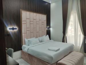 sypialnia z dużym łóżkiem i krzesłem w obiekcie Passready Hotel and Suites Nnewi w mieście Nnewi