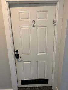 una porta bianca con il numero sopra di Boutique Hotel Room 2 a Northport