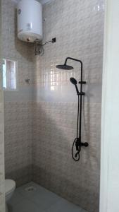 a shower in a bathroom with a toilet at Bamboo House BnB in Bondeni
