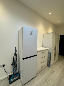 a kitchen with a white refrigerator and a vacuum at Studio room next to Gatwick in Crawley