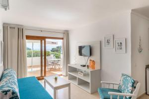 un soggiorno con un divano blu e una TV di Apartamento Erizo de Mar a Felanitx