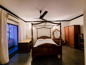 ein Schlafzimmer mit einem Himmelbett und einem Deckenventilator in der Unterkunft VILLA COLOMBO7 5BR HOLIDAY HOME UP to 10 Guests in Colombo