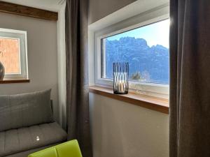 a window with a vase sitting on a window sill at Dolomitenblick Suite in Stronach