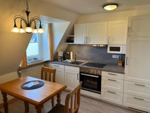 eine Küche mit einem Holztisch und einem Tisch sowie ein Esszimmer in der Unterkunft Haus am Südende Nordsee in Westerland + 7 Fotos
