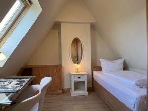 ein Schlafzimmer mit einem Bett, einem Tisch und einem Spiegel in der Unterkunft Haus am Südende Nordsee in Westerland