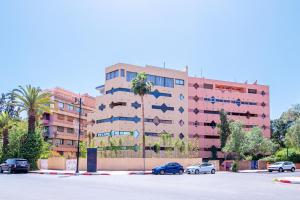 a large building with cars parked in a parking lot at Escale VIP Cœur de l'Hivernage en Face du Sofitel in Marrakech