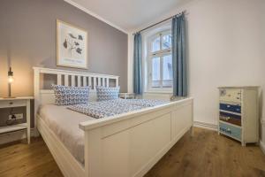 um quarto com uma cama com cortinas azuis e uma janela em Müritzsee 4 em Buchholz