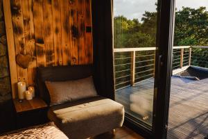 eine Veranda mit einem Stuhl und einem großen Fenster in der Unterkunft Treedom in Prievidza