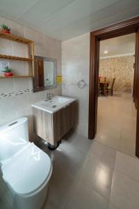 a bathroom with a white toilet and a sink at Welcome to Ville de Companeros in Punta Cana