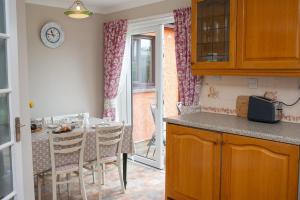 a kitchen with a table and chairs and a dining room at Goitre Bach Llwyncelyn in Llanarth